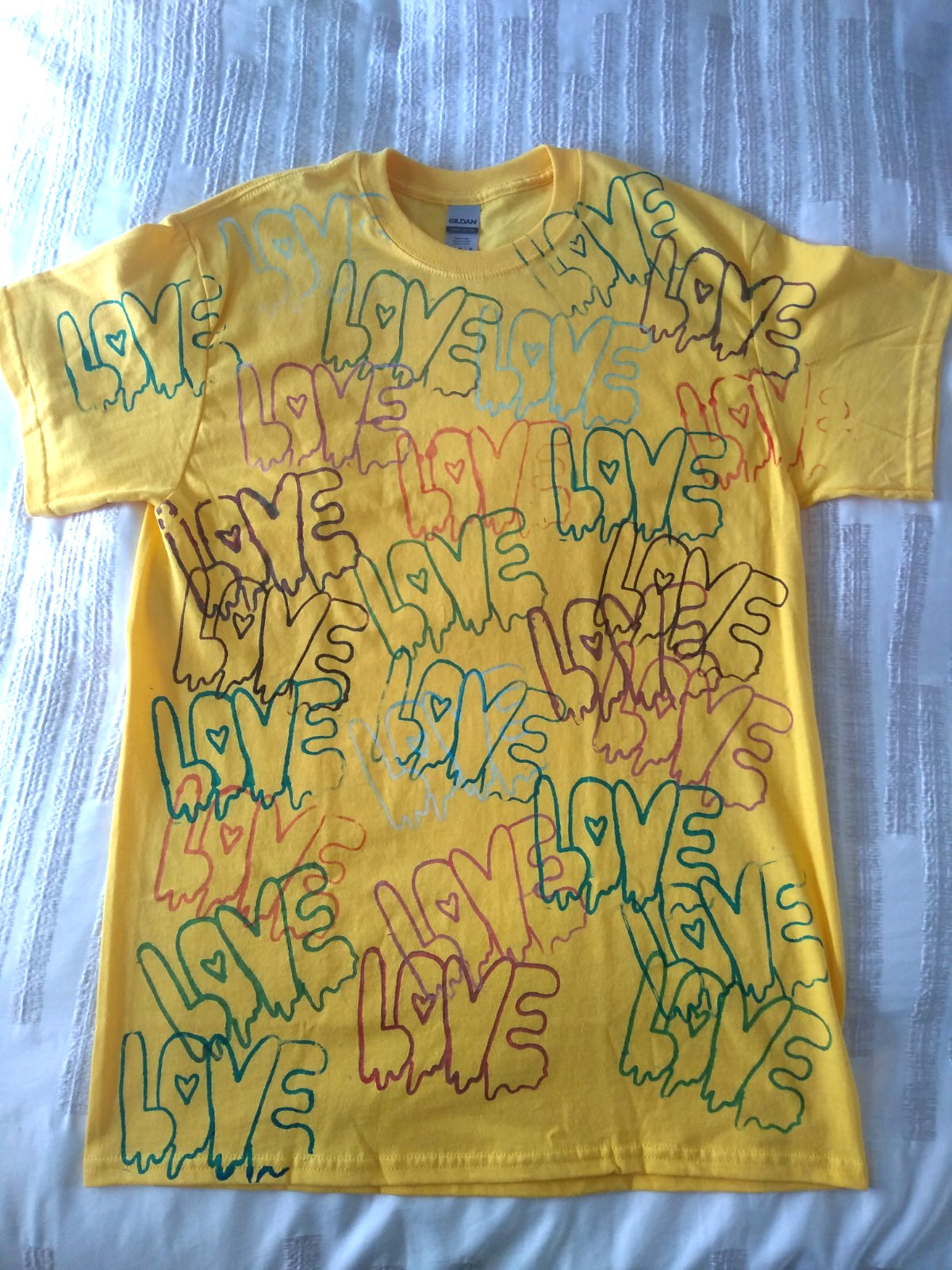 Layed flat yellow tshirt text Love in different colours
