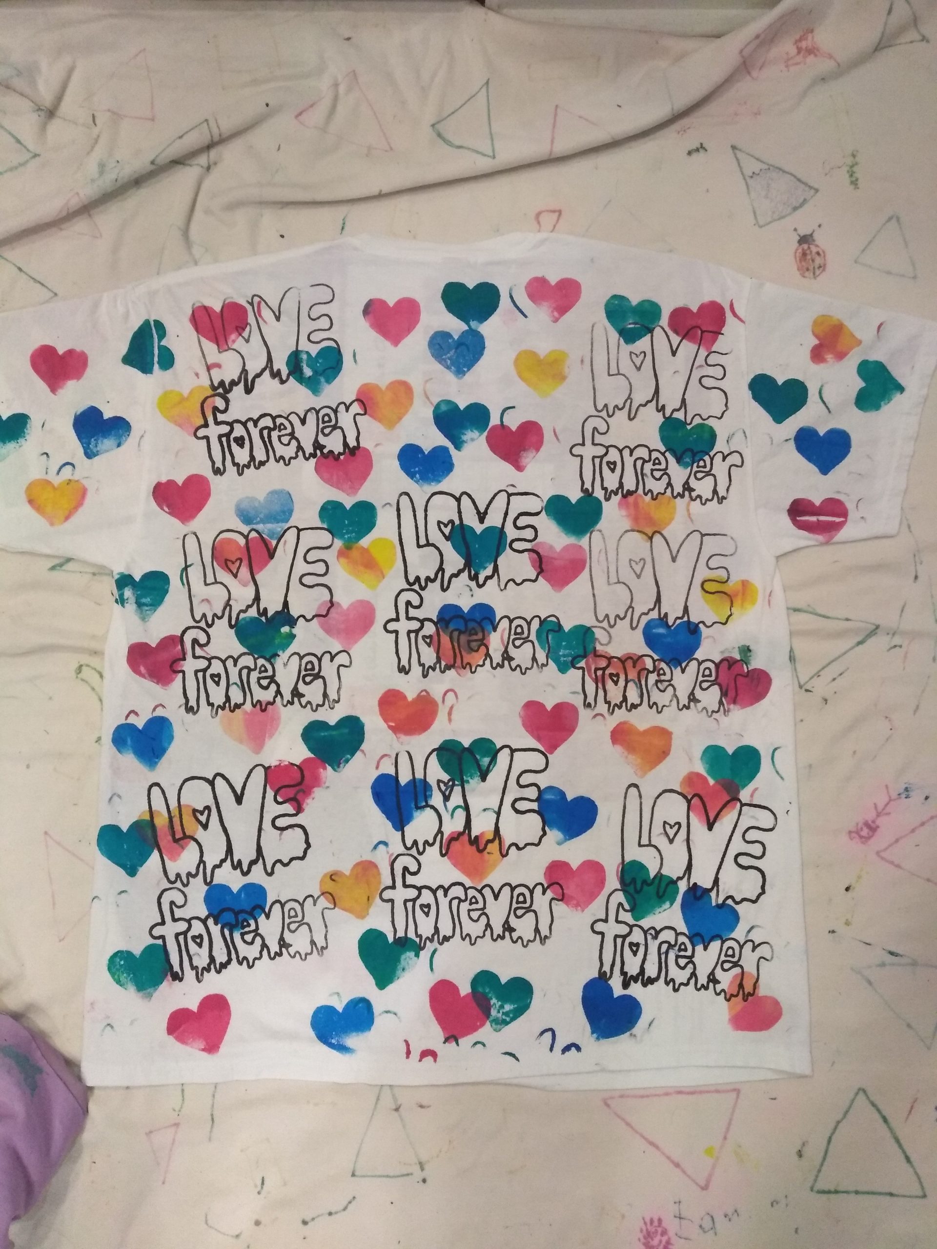 Multi layered colourful hearts printed with text in black Loved forever